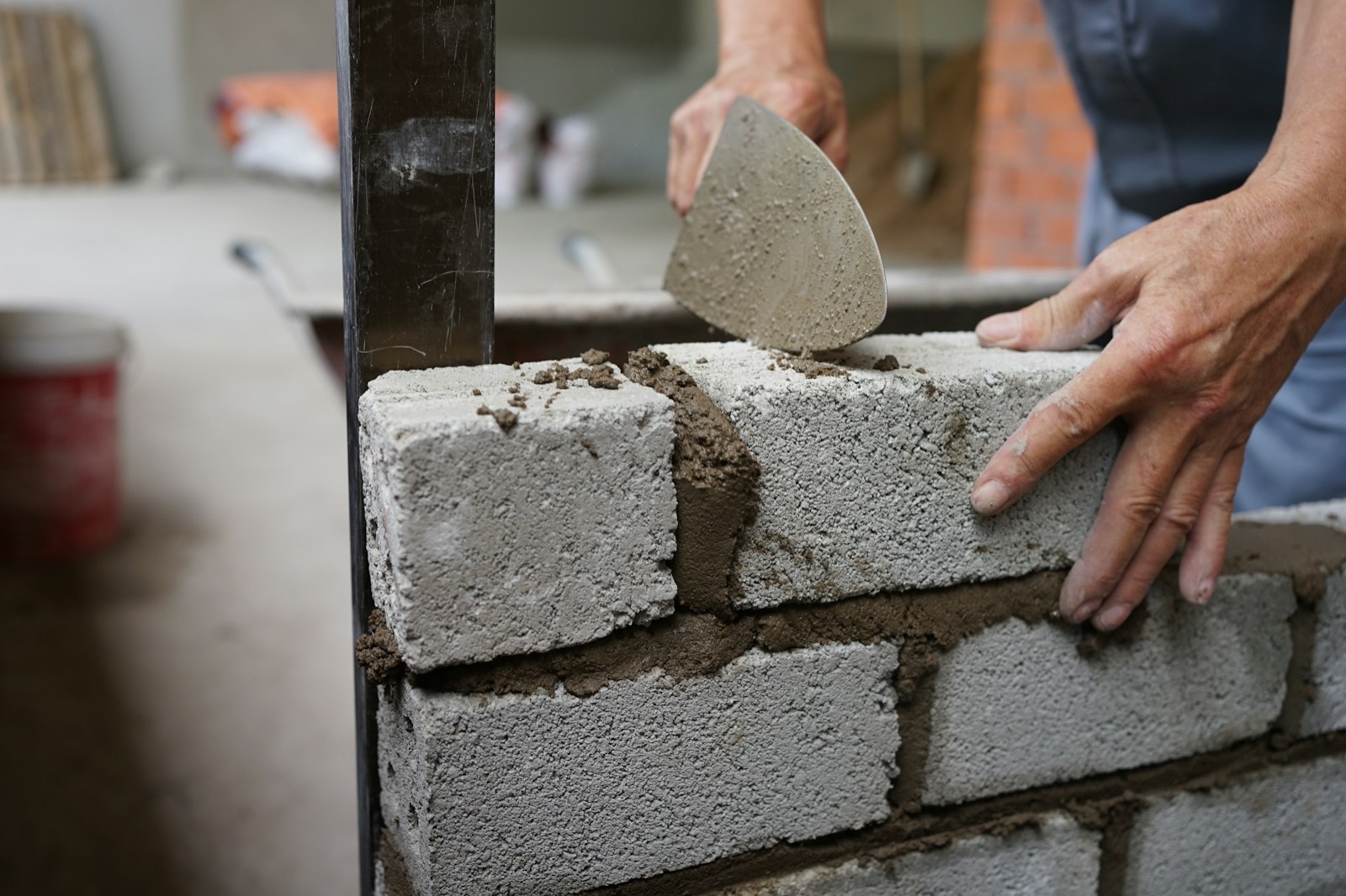 Albañil colocando bloques de concreto con mortero