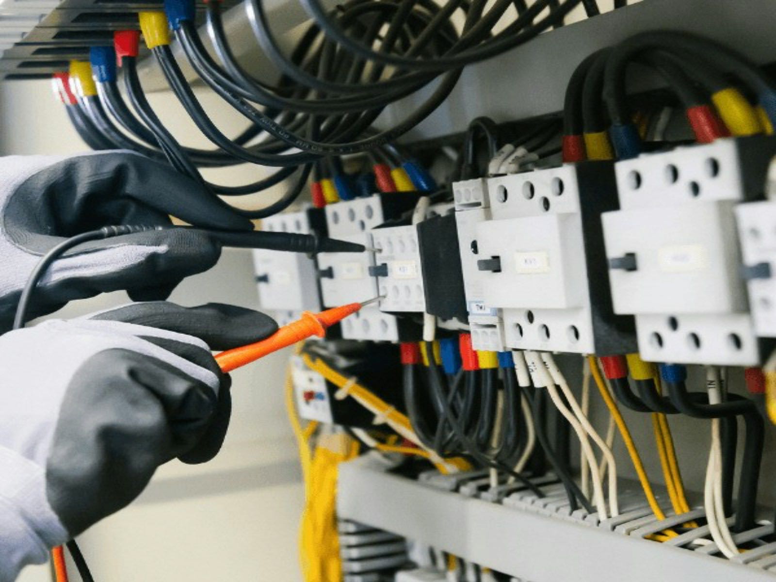 Electricista revisando un tablero eléctrico con multímetro
