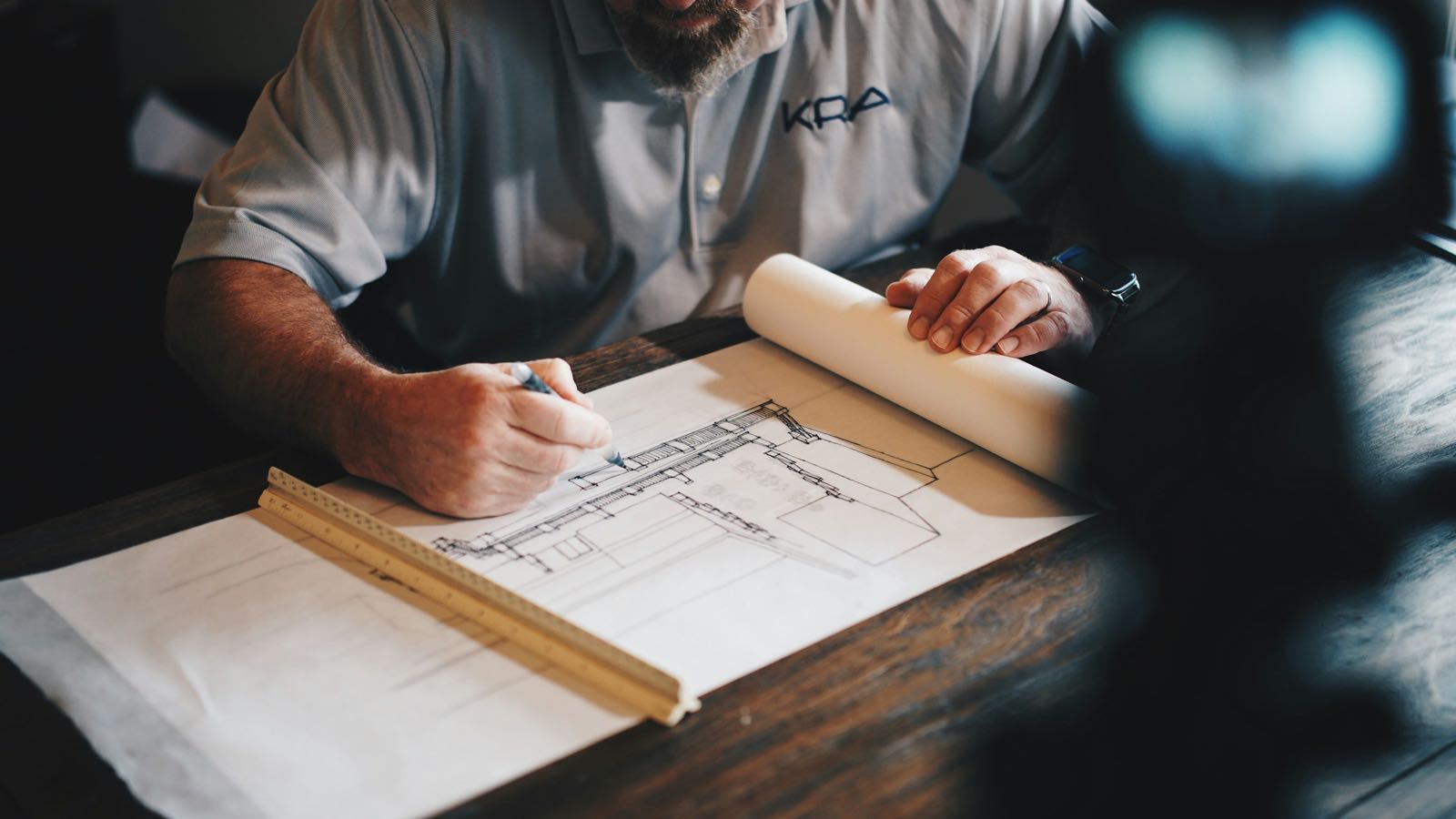 Arquitecto revisando planos sobre una mesa de trabajo