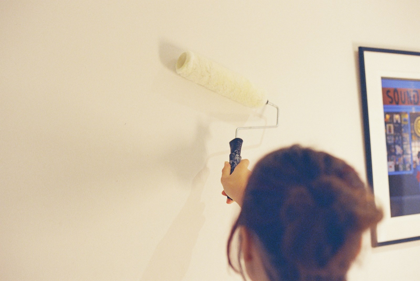 Persona pintando un muro claro con rodillo